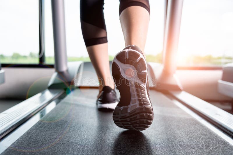 Close up sneakers Fitness girl running on treadmill, Woman with muscular legs in gym