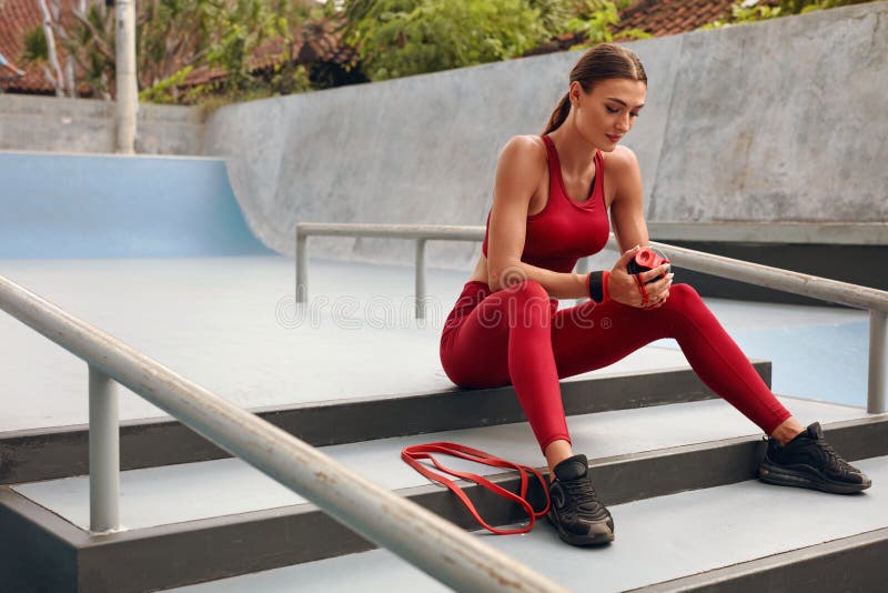 Fitness Girl On Stairs Has Rest. Fit Woman With Strong Muscular Body On Break From Exercising. Fashion Sexy Female.