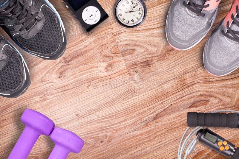 Fitness gym and running equipment. Dumbbells and running shoes, analog stopwatch and music player. Time for fitness and run. royalty free stock photography Fitness gym and running equipment. Dumbbells and running shoes, analog stopwatch and music player. Time for fitness and run. royalty free stock photography