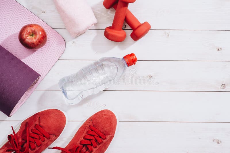 Fitness, healthy and active lifestyles Concept, dumbbells, sport shoes, bottle of waters and apple on wood background. Fitness, healthy and active lifestyles royalty free stock photography Fitness, healthy and active lifestyles Concept, dumbbells, sport shoes, bottle of waters and apple on wood background. Fitness, healthy and active lifestyles royalty free stock photography