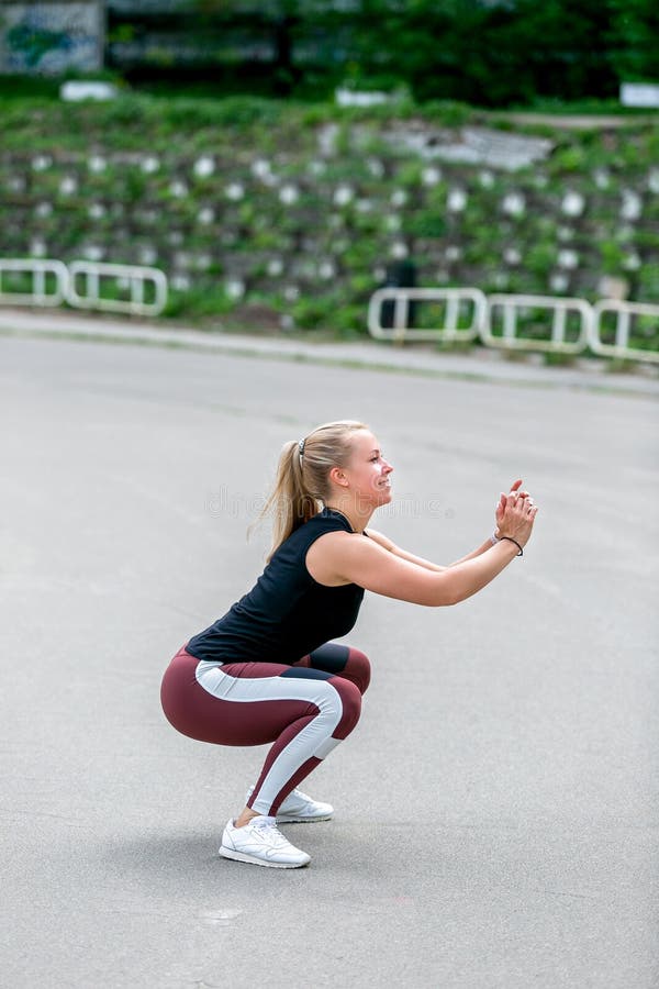 Fitness lifestyle. Young woman jumping up. Sporty young blonde girl on a sunny day at the stadium. Healthy life concept. Vertical royalty free stock photography Fitness lifestyle. Young woman jumping up. Sporty young blonde girl on a sunny day at the stadium. Healthy life concept. Vertical royalty free stock photography