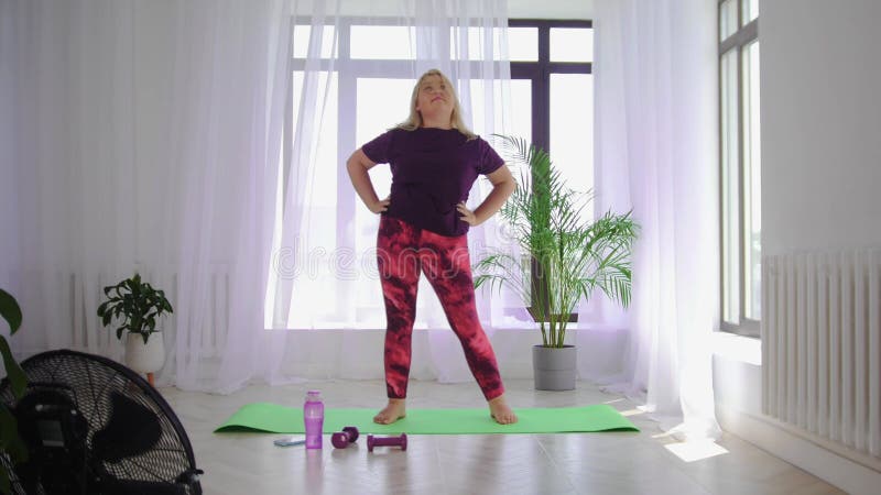 Fitness-Training blonde übergewichtige Frau tun Fitness-Übungen wärmen ihren Körper mit Kreis Bewegungen