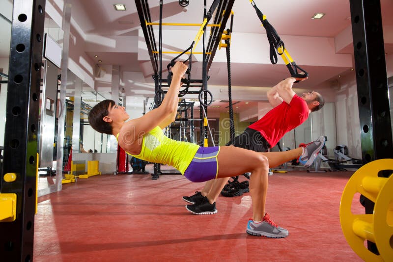 Fitness TRX training exercises at gym woman and man stock photo