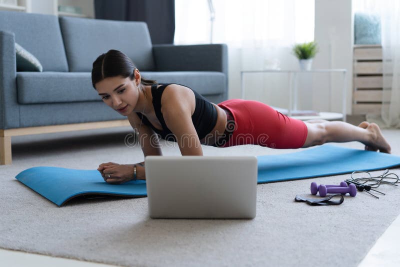Fitness Woman Exercising on the Floor at Home and Watching Fitness ...