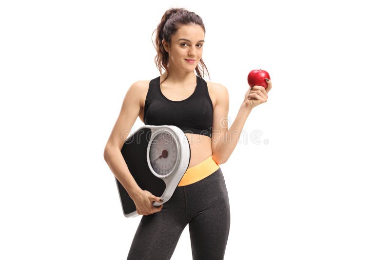 Fitness woman holding a weight scale and an apple royalty free stock images Fitness woman holding a weight scale and an apple royalty free stock images