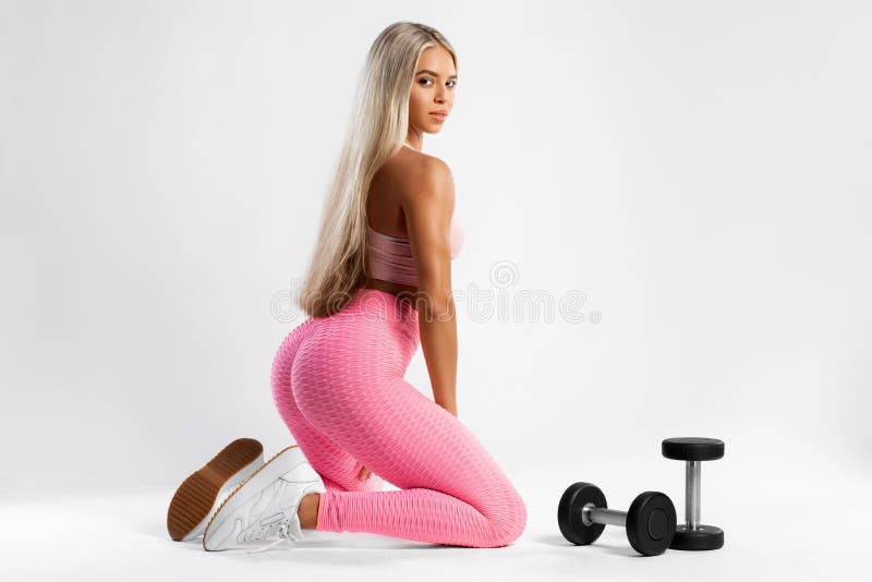 Fitness woman in leggings on gray background. Athletic girl with beautiful butt.