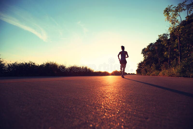 Young fitness woman running on sunrise seaside trail. Determined jogger stock images, royalty-free photos and pictures