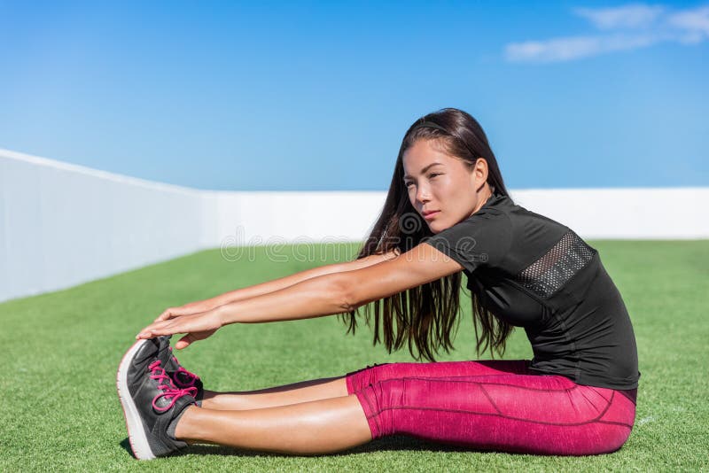 Fitness woman stretching sitting toe touch stretch. Fitness woman stretching hamstring leg muscles - back stretch sitting toe touch stretches. Seated forward stock images