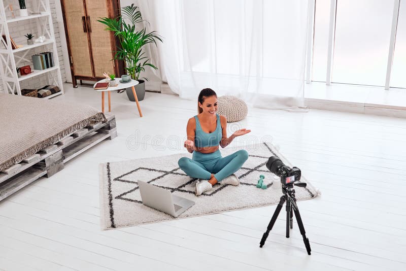 Fitnesslogg. Bilder av aktiv ung kvinna som filmar video för sin Internetkanal på sociala medier som tittar och pratar med kameran royaltyfri fotografi