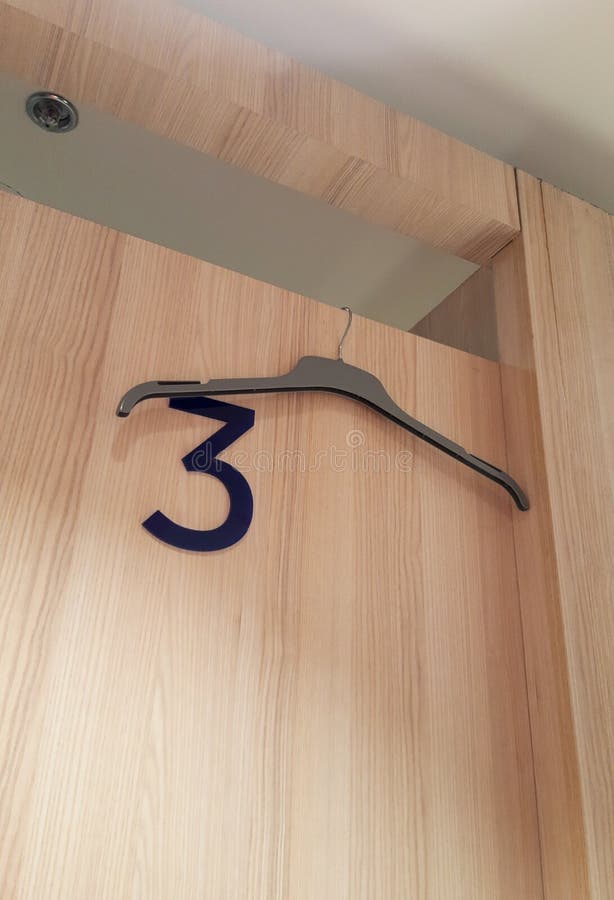 In the Fitting Room of the Store, a Hanger Hangs on the Doors Stock