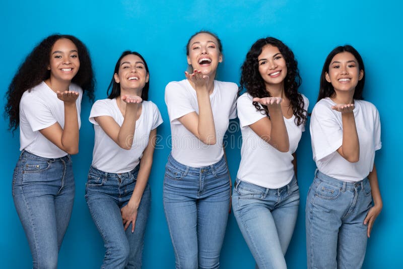 Five Cheerful Multicultural Ladies Sending Air Kisses Over Blue Background royalty free stock image