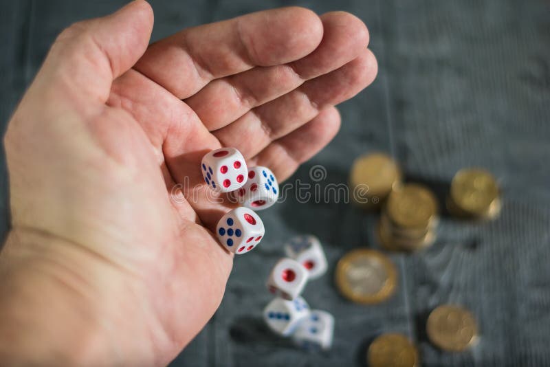 Five Dice Roll with Left Hand Men on the Table with Money. Stock Photo