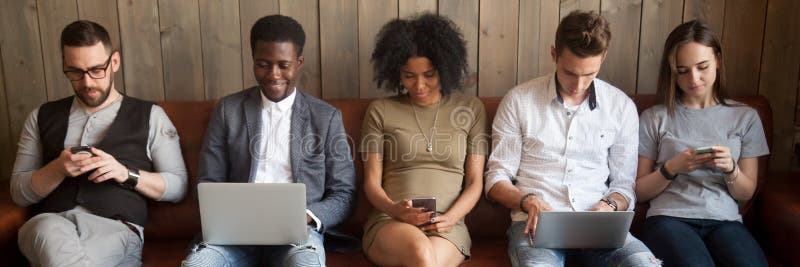 Five diverse businesspeople girls guys sitting on couch using gadgets stock images