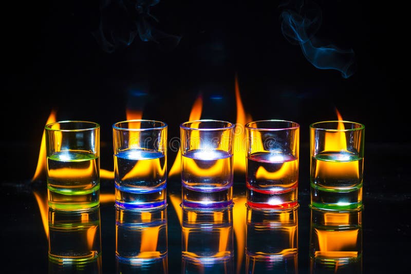 Five Multicolored Full of Drinks Shot Glasses Reflected on the G Stock