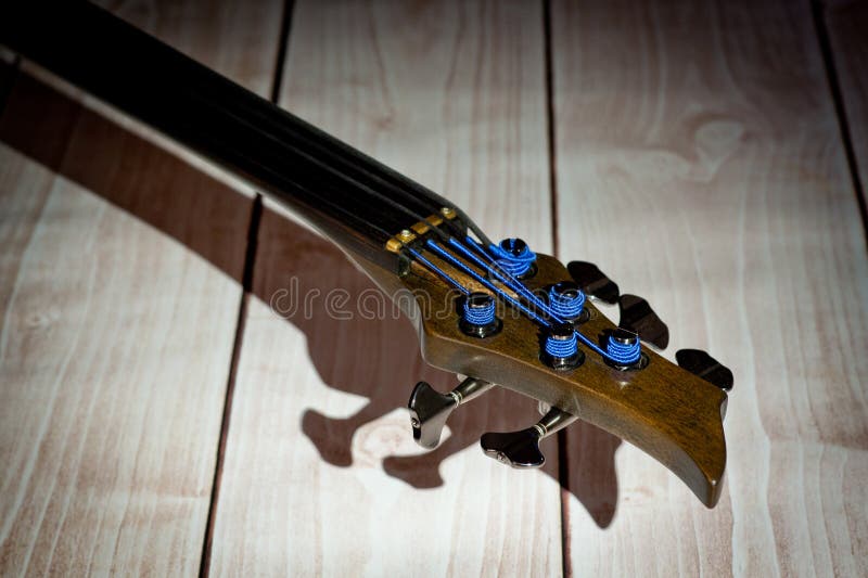 Five-string electric dark wood bass. Background for music and creativity stock photo Five-string electric dark wood bass. Background for music and creativity stock photo