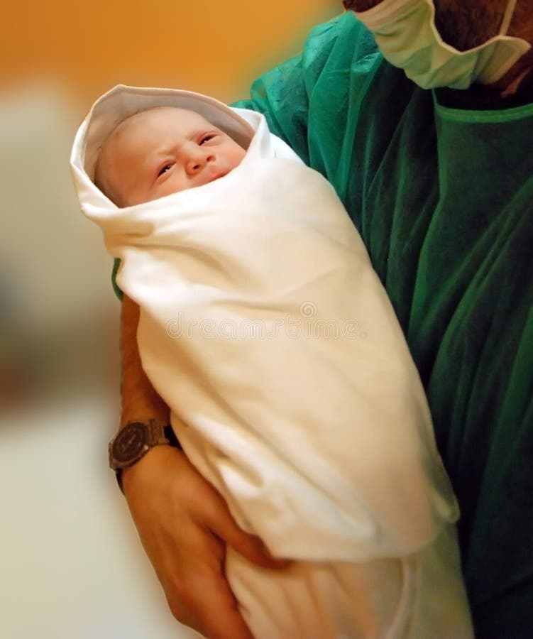 Close up of surgeon holding newborn baby. Close up of surgeon holding newborn baby.