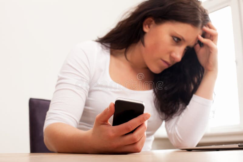 Fixation frustrante de femme son téléphone photos stock Fixation frustrante de femme son téléphone photos stock