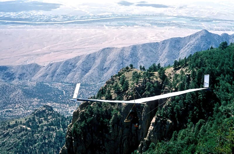 A fixed-wing glider pilot steps into his body harness after a successful launch from Sandia Crest @ 10,678` elevation, overlooking Albuquerque, NM, USA; The Rio Grande River is the river in the background;. A fixed-wing glider pilot steps into his body harness after a successful launch from Sandia Crest @ 10,678` elevation, overlooking Albuquerque, NM, USA; The Rio Grande River is the river in the background;