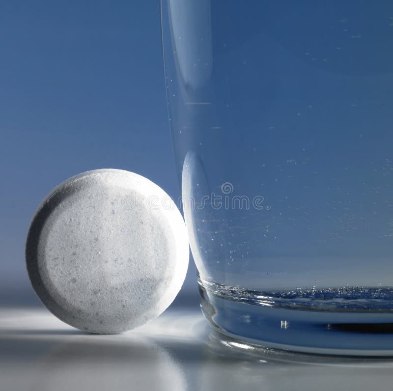 Sprudelnde Tablette neben einem Glas Wasser lizenzfreie stockbilder Sprudelnde Tablette neben einem Glas Wasser lizenzfreie stockbilder