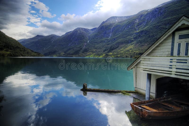Eine Norwegische malerischen, einen fishermans-Hütte mit einem Schiff geparkt.