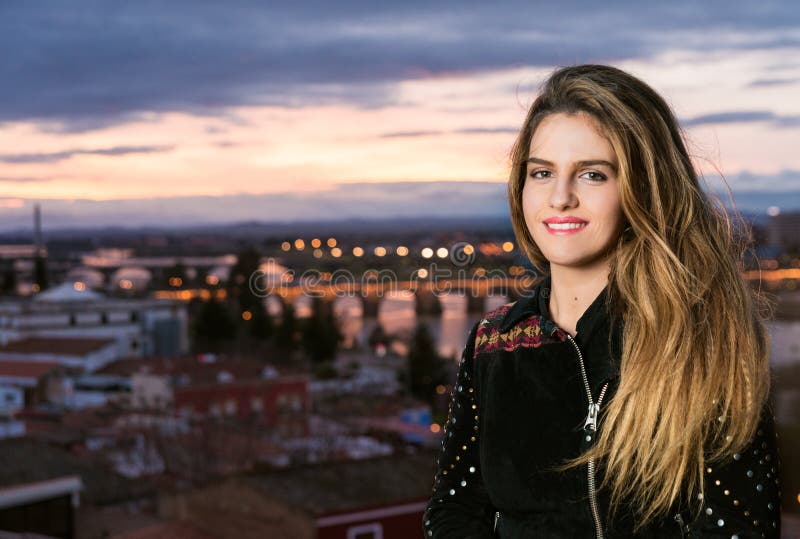 Fjädra utomhus- porttrait av den unga nätta blonda flickan med stad b arkivbild Fjädra utomhus- porttrait av den unga nätta blonda flickan med stad b arkivbild
