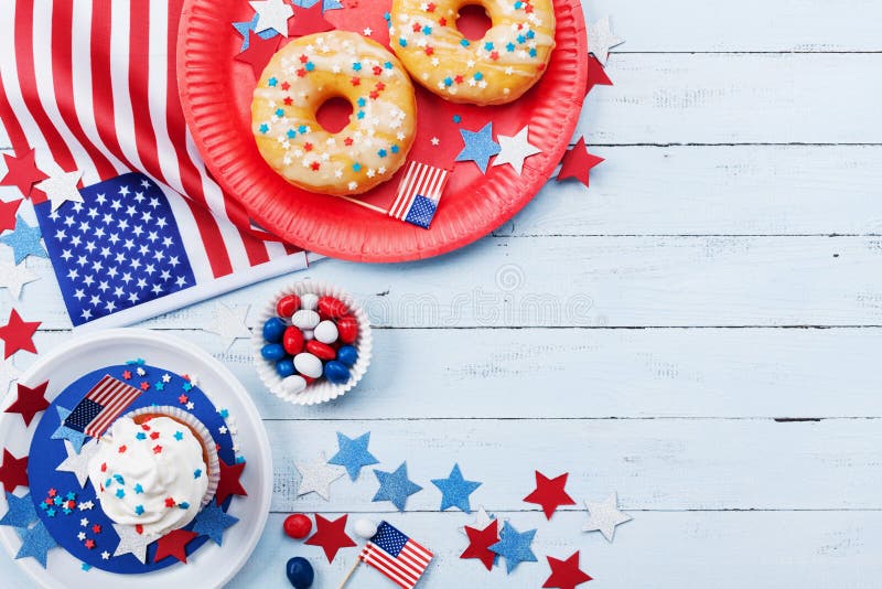 Fourth of July american Independence Day background decorated with USA flag, donut with candy, stars and confetti. Fourth of July american Independence Day background decorated with USA flag, donut with candy, stars and confetti.