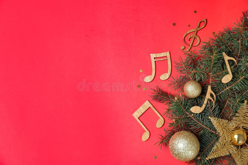 Flache gelegte Komposition mit Tannenbaum, Weihnachtsdekor und hölzernen Musikanmerkungen über Farbhintergrund
