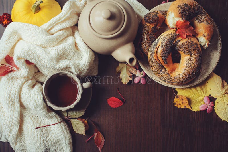 Flache Lage des gemütlichen Herbstfrühstücks auf Tabelle im Landhaus Heißer Tee, Kürbise, Bagel und Blumen stockfoto