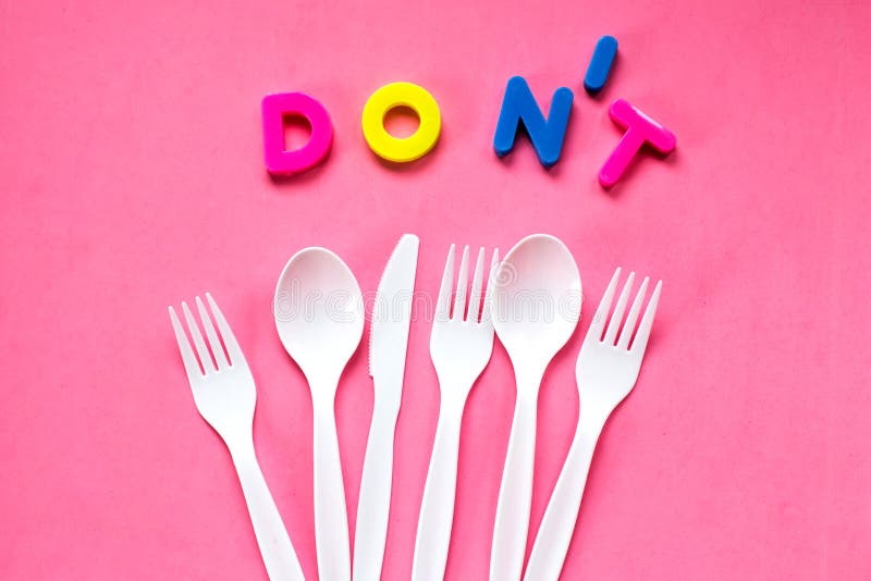 Flache Lage des weißen Plastiktischbestecks auf rosa Hintergrund Wiederverwertung des Konzeptes lizenzfreie stockfotos Flache Lage des weißen Plastiktischbestecks auf rosa Hintergrund Wiederverwertung des Konzeptes lizenzfreie stockfotos