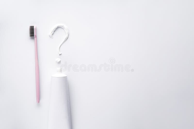 Flache Laien Zusammensetzung des Fragezeichens Zahnpasta und der Zahnbürste auf einem weißen Hintergrund. Raum für Text stockfotografie
