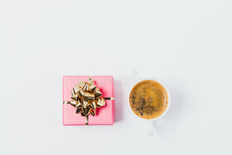 Flacher Plan des Tasse Kaffees nahe bei rosa Geschenkbox stockfotos