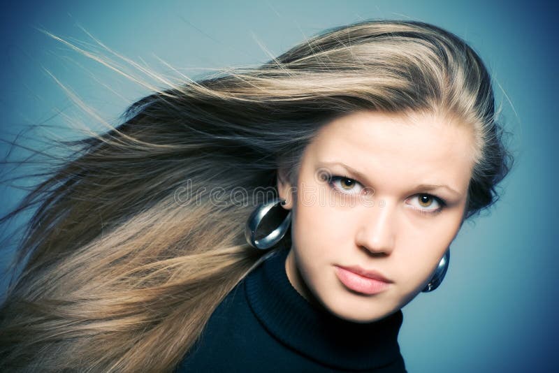 Woman with fluttering hair. On blue background. Woman with fluttering hair. On blue background.