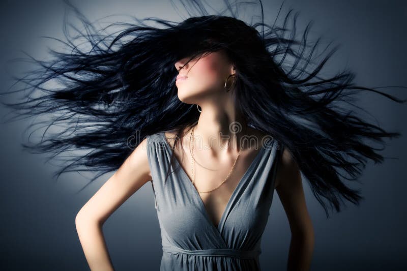 Woman with fluttering hair. On dark background. Woman with fluttering hair. On dark background.