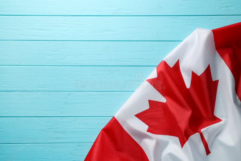 Flag of Canada on Turquoise Wooden Table, Top View. Space for Text