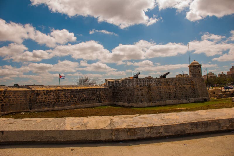 Cuba, Havana. Fortress wall and Cuban flag at San Carlos de