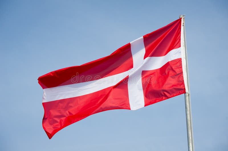 Vlajka z dánsko na modrej oblohe.