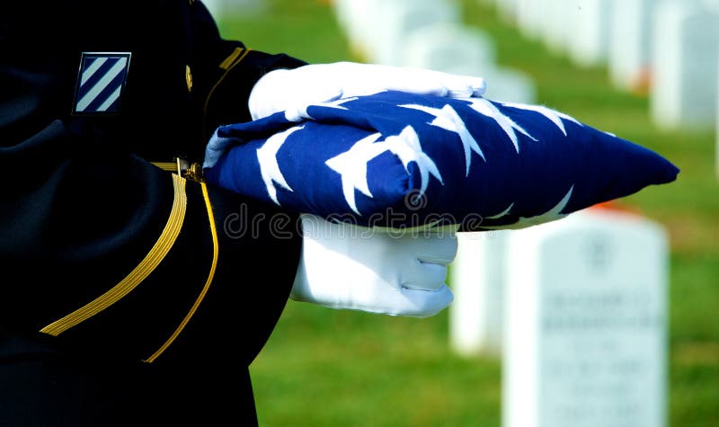 Guardia d'onore holding piegato bandiera Americana a luogo di sepoltura al Cimitero Nazionale di Arlington.