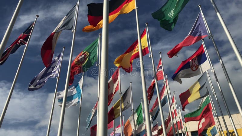 Flaggor av många länder som vawing i vinden med blå himmel och vita moln för politiskt internationell handel, förhållandeconcep