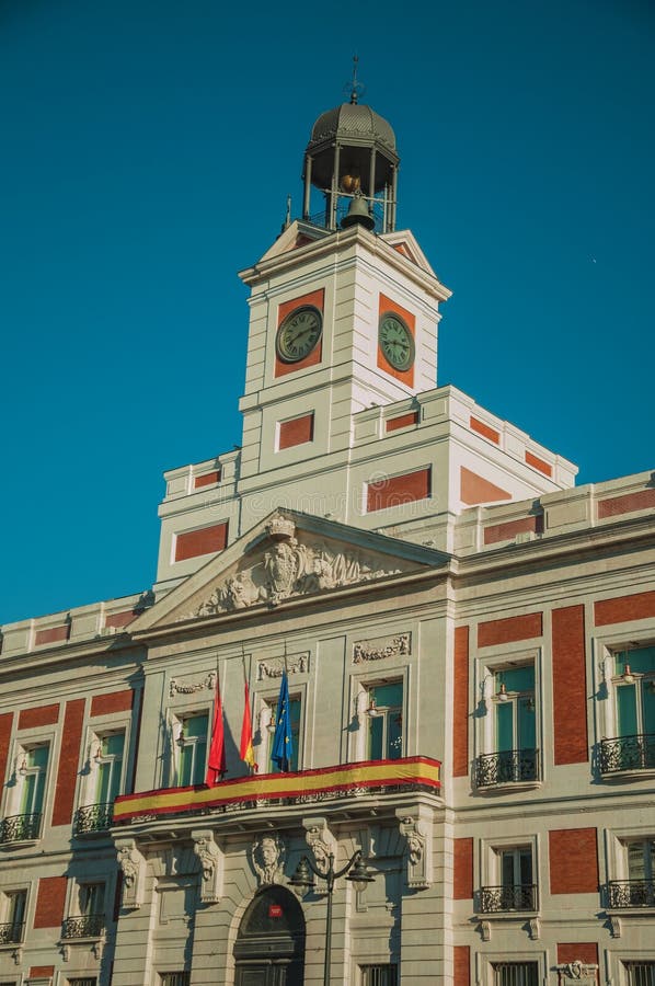 Flags on exquisite old building with bell tower and clock in Madrid stock photo Flags on exquisite old building with bell tower and clock in Madrid stock photo