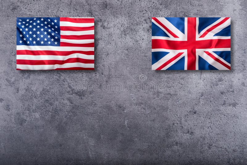 Flags of the USA and the UK. Union Jack flag on concrete background.