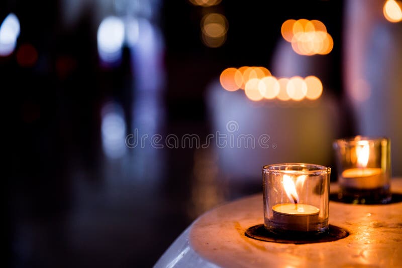 Flame of Many Candles Burning on Blurred Lights Background. Stock Image