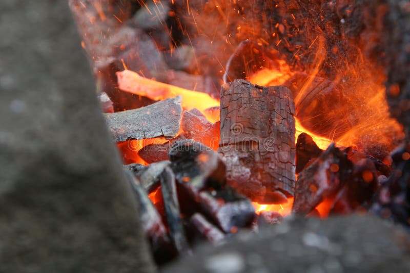 A craftsman/blacksmith working metal the oldfashioned way, with hammer and anvil and open fire. A craftsman/blacksmith working metal the oldfashioned way, with hammer and anvil and open fire