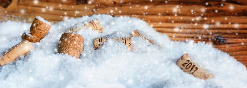 Bottle corks new year 2017 in snow in front of a wooden wall. Bottle corks new year 2017 in snow in front of a wooden wall