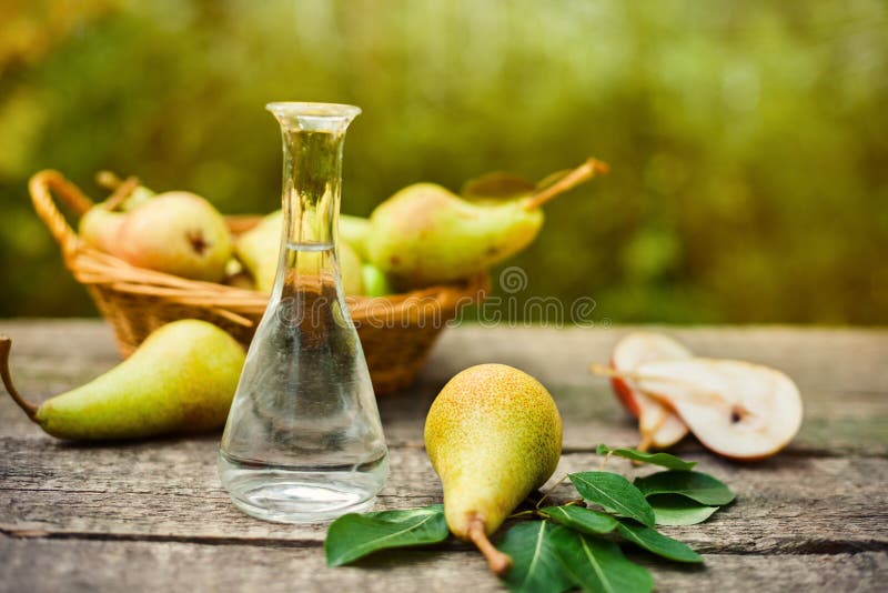 Flasche des Obstbranntweins und der Birne stockfotografie