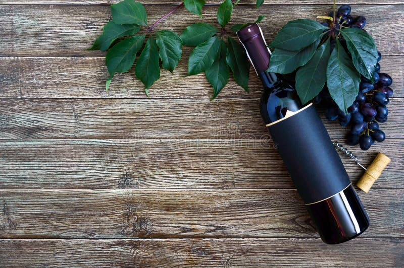 Flasche mit Rotwein, Korkenzieher, blaue Trauben, Blätter auf einem Holztisch Weinhintergrund mit Kopierraum Obere Ansicht, flach stockfoto