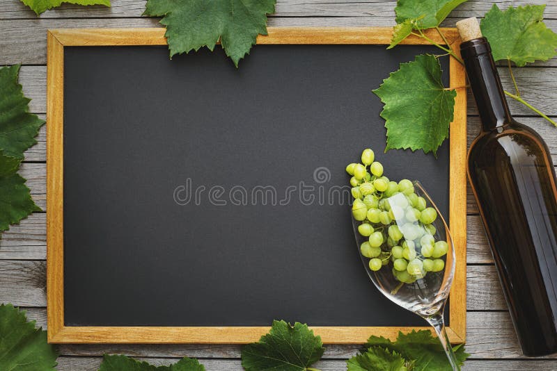 Flasche Wein mit Glas und Weintrauben mit Blättern auf einem Holztisch mit Kopierraum Weinwirtschaftskonzept stockfotografie