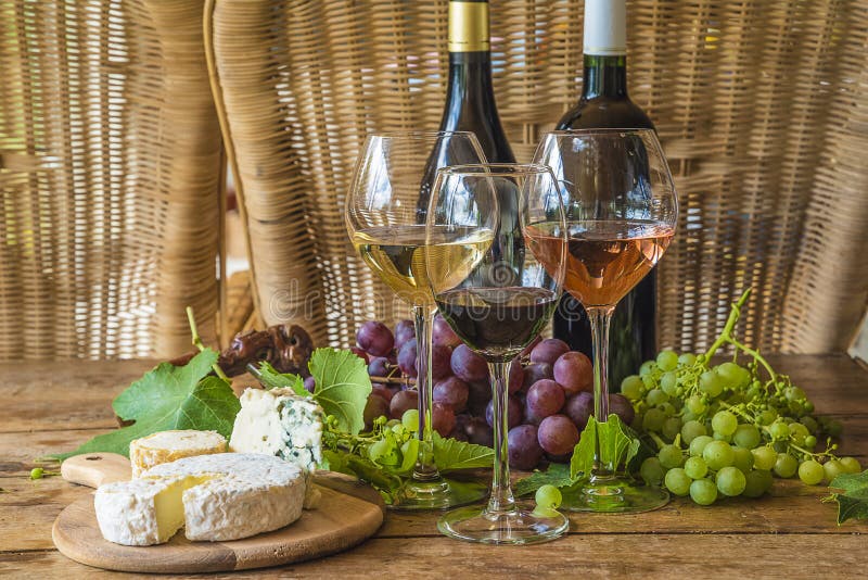 Flasche zwei Wein und drei Gläser weißer, rosa und Rotwein lizenzfreie stockfotografie