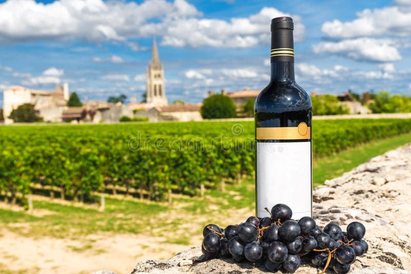 Flaska av rött vin mot bakgrunden av vingårdar av Saint Emilion, Bordeaux, Frankrike