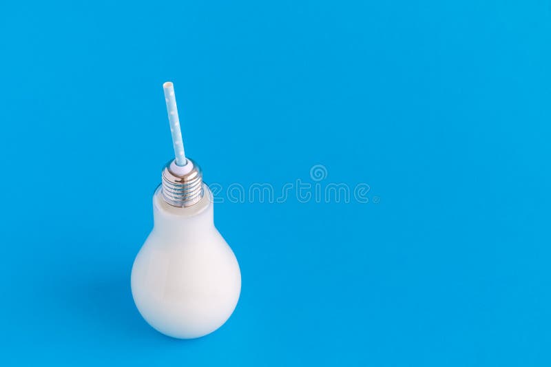 Flaskan för den Glass kulan av mjölkar på blå bakgrund arkivfoto Flaskan för den Glass kulan av mjölkar på blå bakgrund arkivfoto