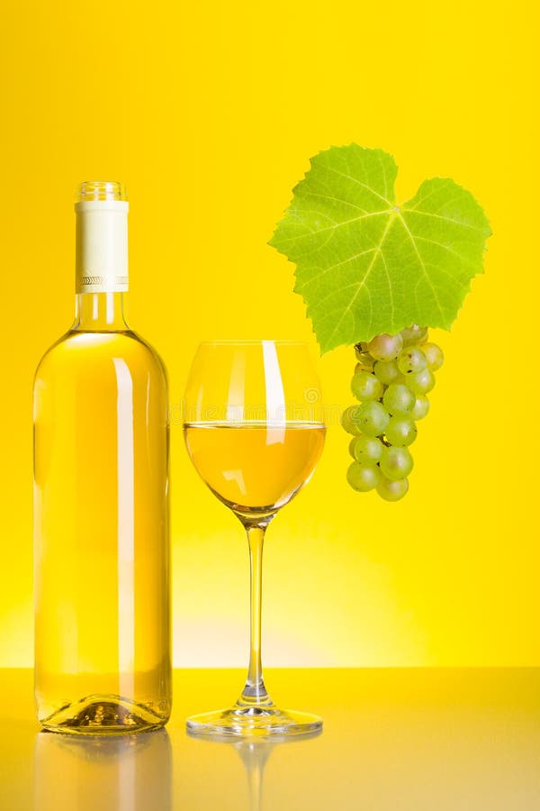Flaskan och exponeringsglas av vitt vin med druvan samla i en klunga royaltyfri foto Flaskan och exponeringsglas av vitt vin med druvan samla i en klunga royaltyfri foto